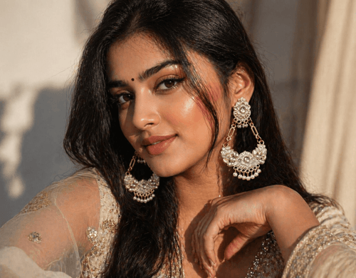 Close-up of an Indian woman wearing elegant pearl and kundan jhumka earrings with ethnic attire, styled in soft warm lighting for a premium jewellery look.