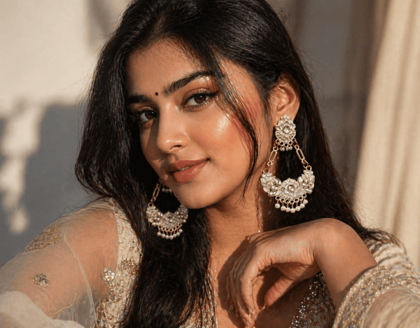 Close-up of an Indian woman wearing elegant pearl and kundan jhumka earrings with ethnic attire, styled in soft warm lighting for a premium jewellery look.