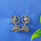 Oxidised silver peacock jhumka earrings with two-tier bell dangle and circular motif