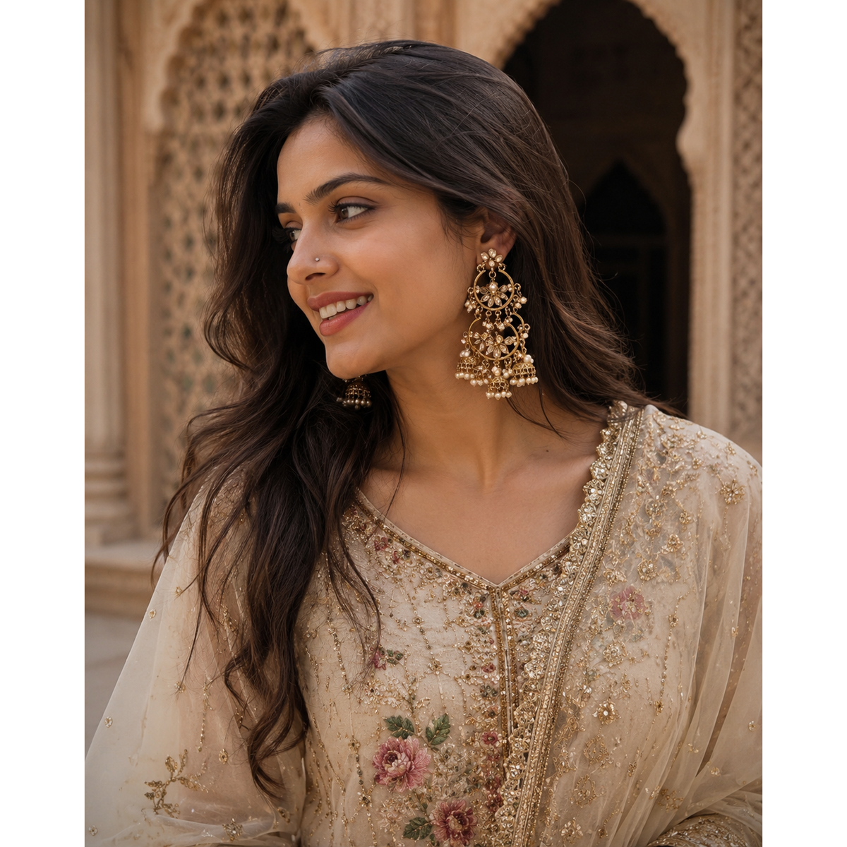 Gold-toned pearl chandbali earrings with dangling floral drops on model