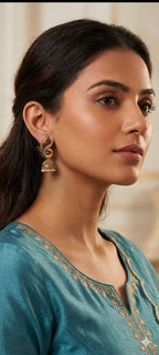 Antique gold jhumka earrings with dangling center charm, side profile view