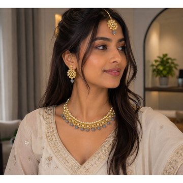 Gold pearl kundan necklace and earring set worn on dark hair with