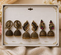 Antique gold jhumka earring set in box, three pairs with dangling bell drops