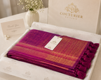 Magenta and gold jacquard woven shawl with tasseled ends, folded in gift box