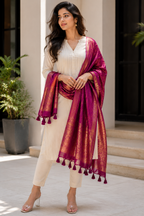 Magenta and gold jacquard shawl draped over shoulders with tassels and fringe